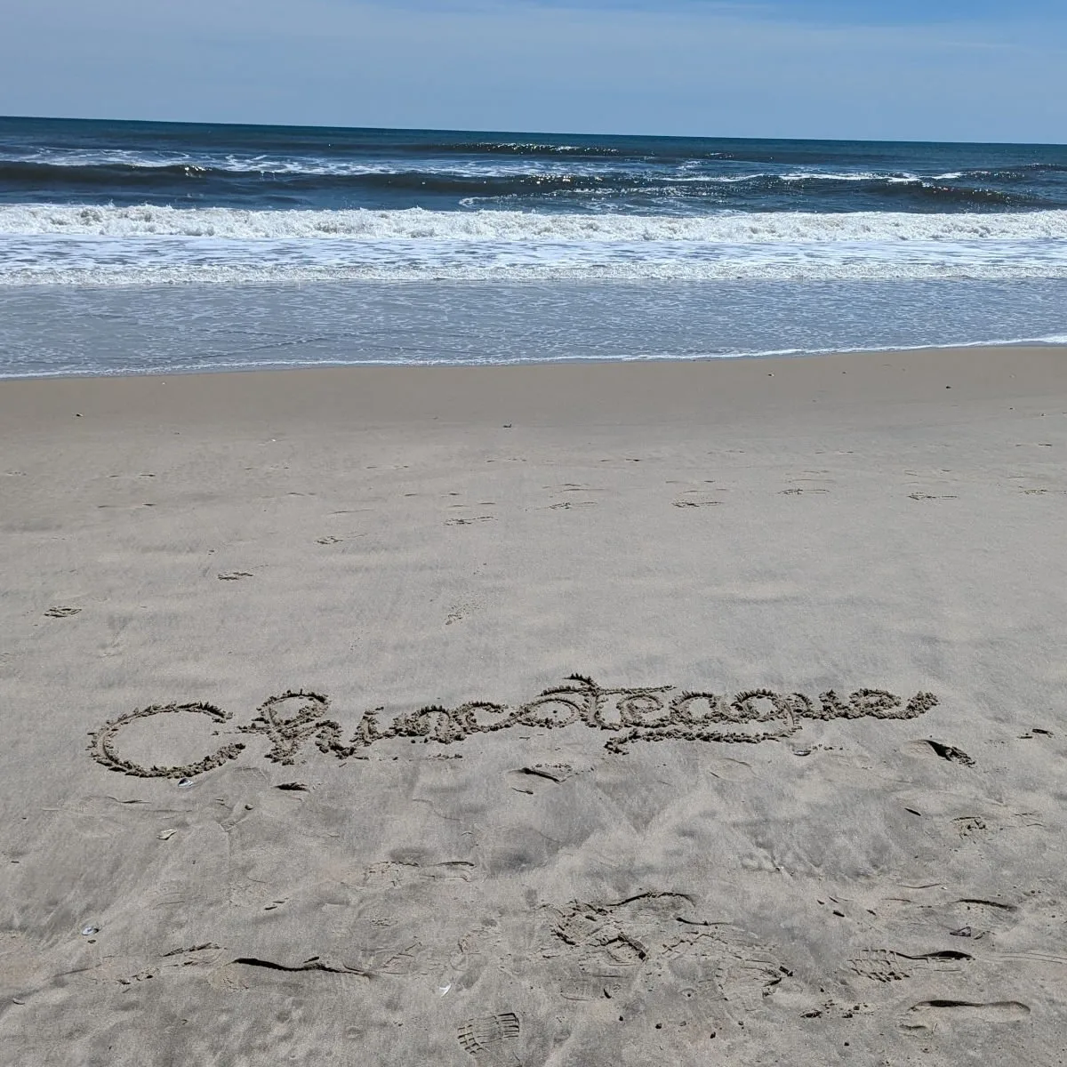 "Chincoteague" written in sand on beach