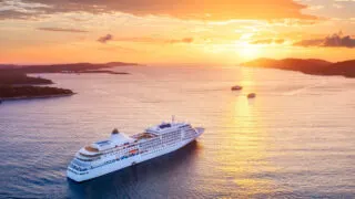 Cruise ship sailing in the ocean at sunset