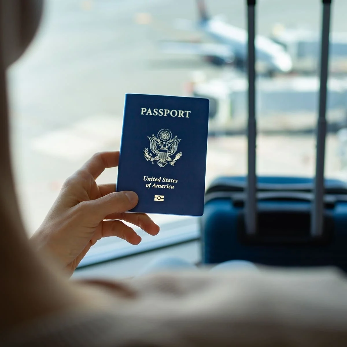 A Young Woman Holding Up A U.S. Passport, American Passport, At The Airport