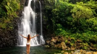 Female tourist visiting majestic waterfall in Fiji