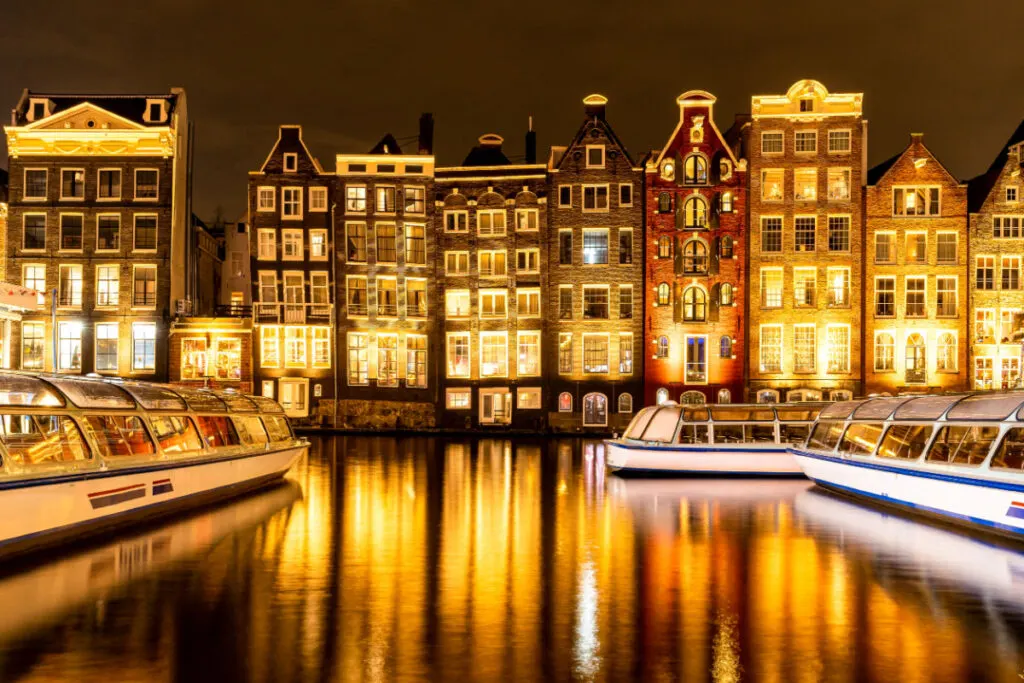 Typical Amsterdam buildings reflected in the canal at dusk