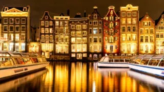 Typical Amsterdam buildings reflected in the canal at dusk
