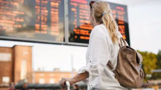 Female train passenger viewing departure board