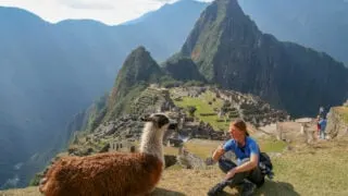 Woman sitting with alpaca at Machu Pichu
