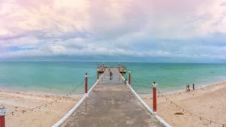 Pier in Sisal, Mexico over emerald waters