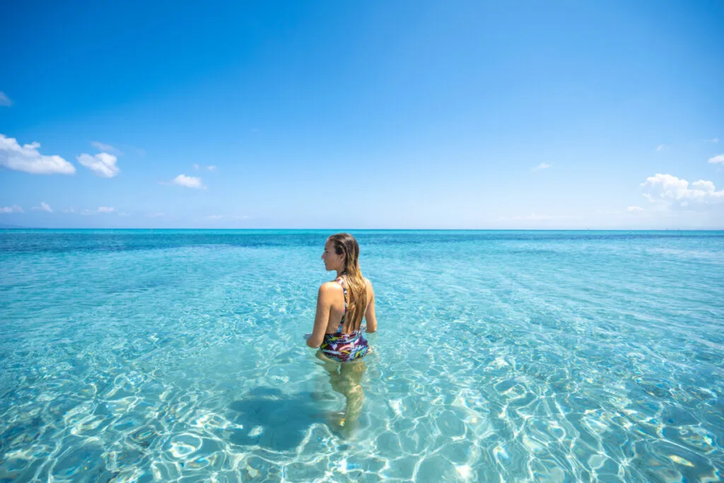 Woman in crystal-clear waters in Sardinia's Stintino beach