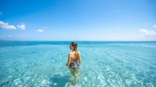 Woman in crystal-clear waters in Sardinia's Stintino beach