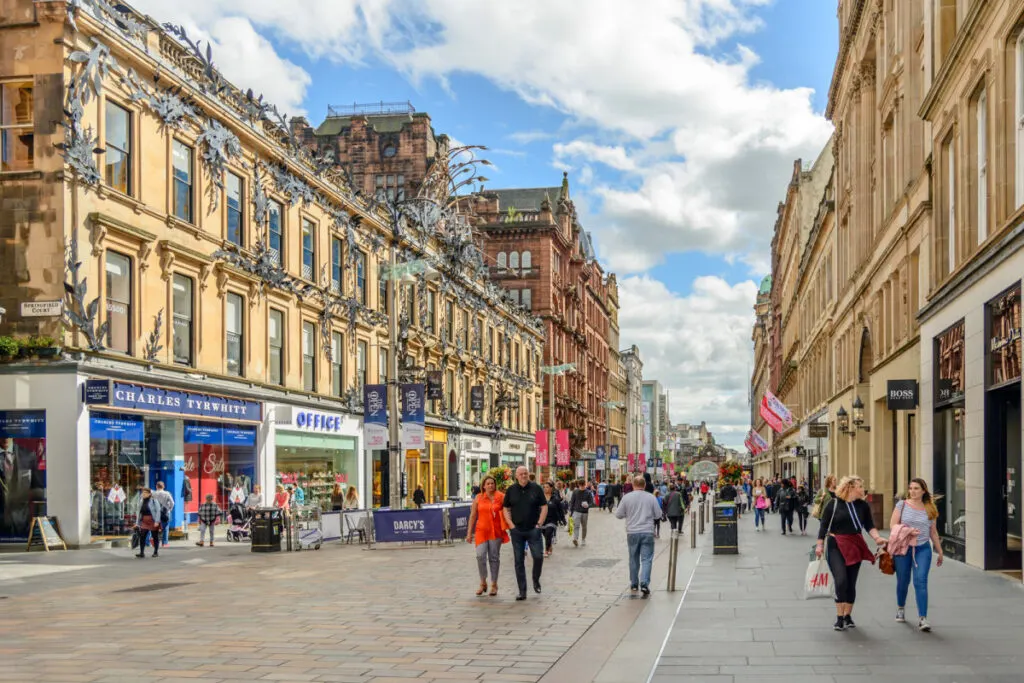 People walking down historic street in Glasgow