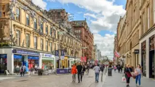 People walking down historic street in Glasgow