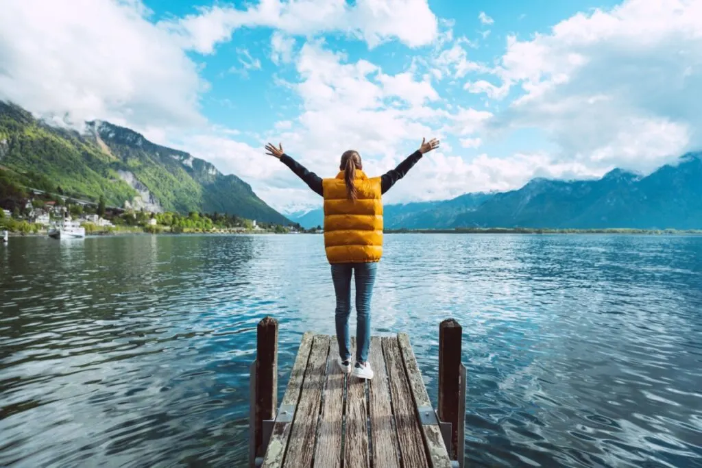 A solo female traveler by a lake in Switzerland