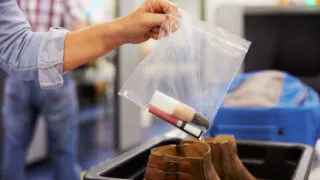 Passenger Puts Liquids Into Bag At Airport Security Check