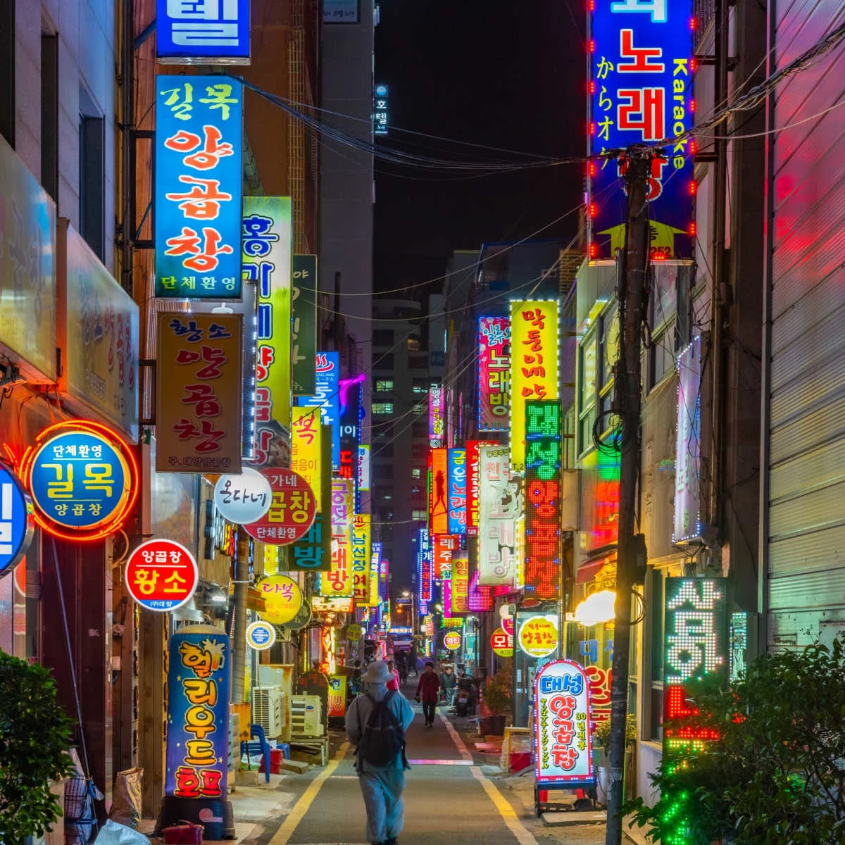 People walking down neon-lit street in Busan, South Korea