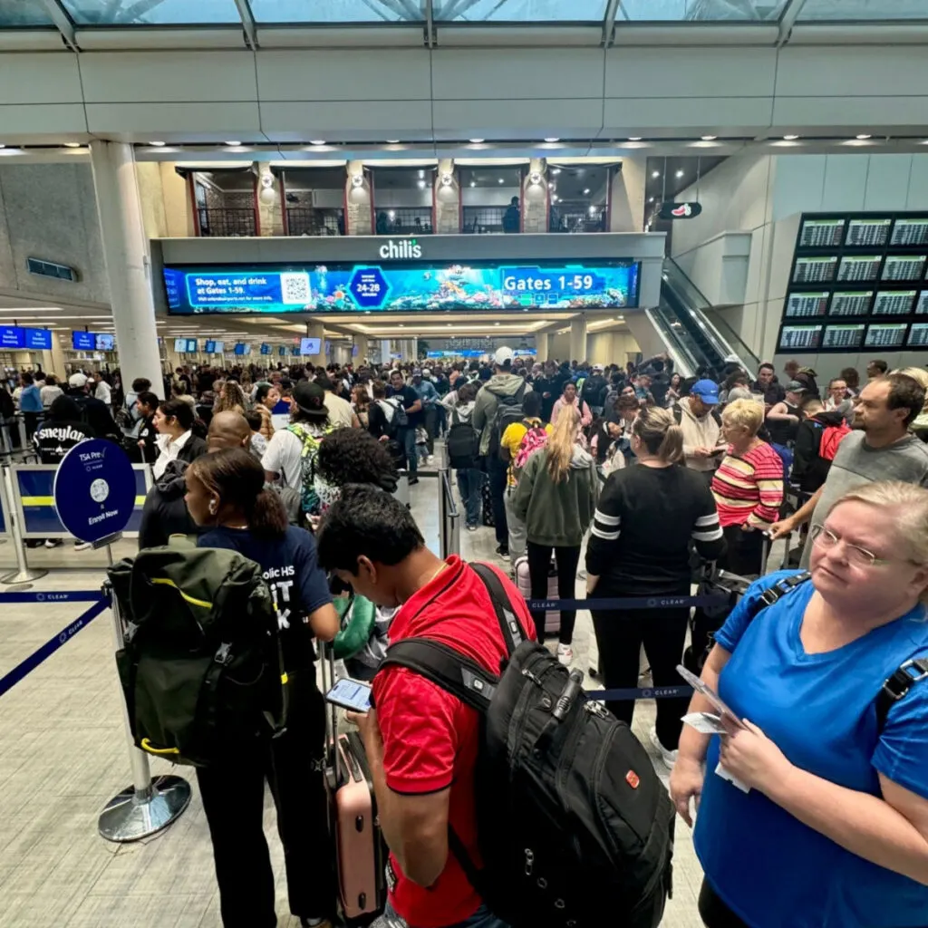 People walking through the busy security line packed with people at Orlando International Airport