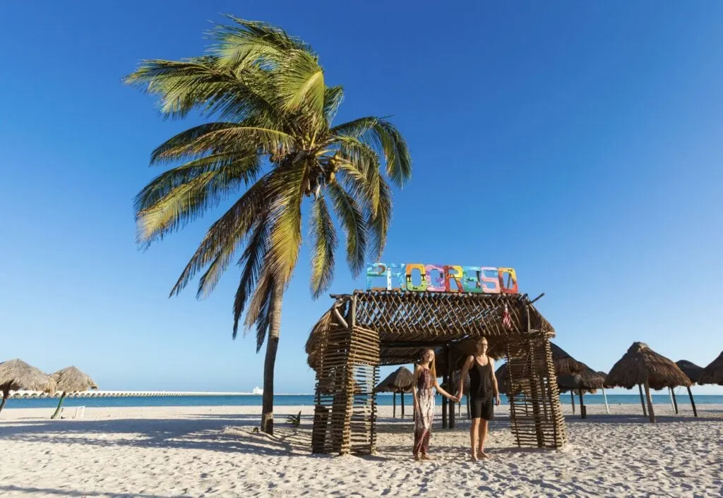 Progeso letter on beach with happy couple