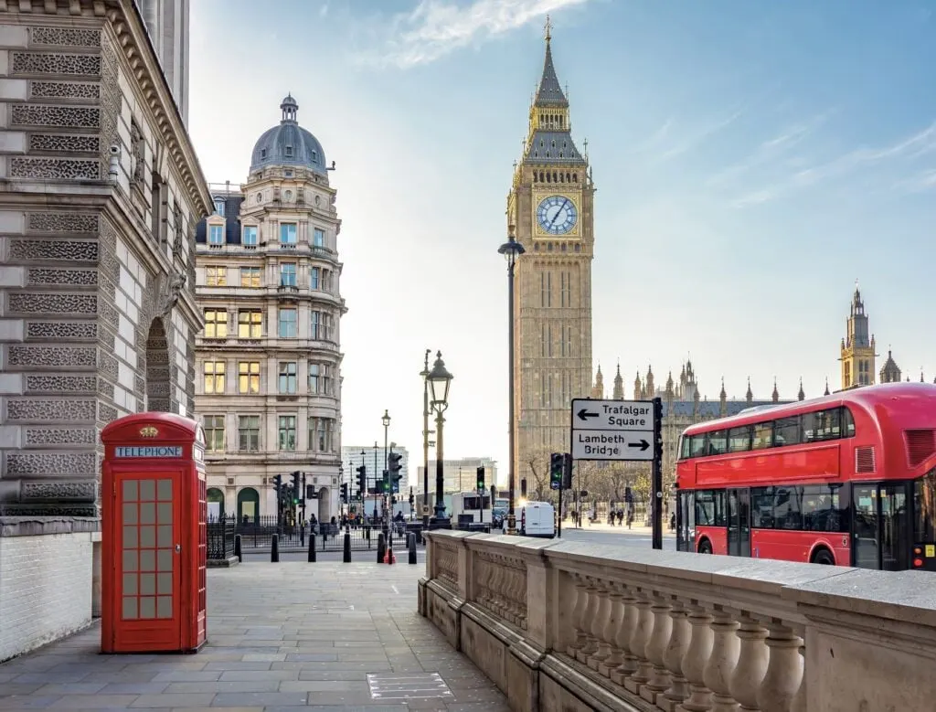 Red telephone box and double-decker bus on Parliament square and Big Ben tower, London, UK