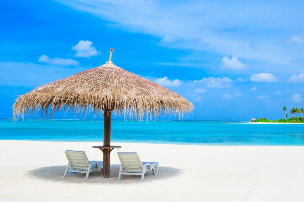 Maldives beach with beach umbrella and chairs