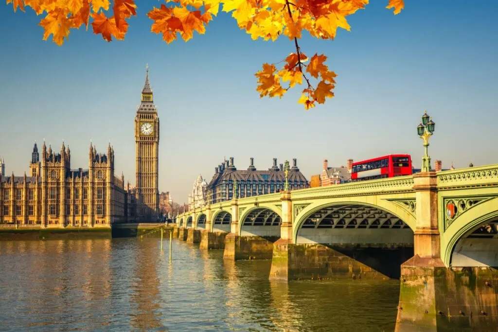 Red bus passing by Big Ben in London