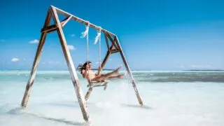 Woman on beach swing in the Bahamas