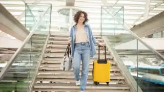 Happy traveler with luggage at airport