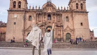 Travelers posing in front of Cusco cathedral in Peru