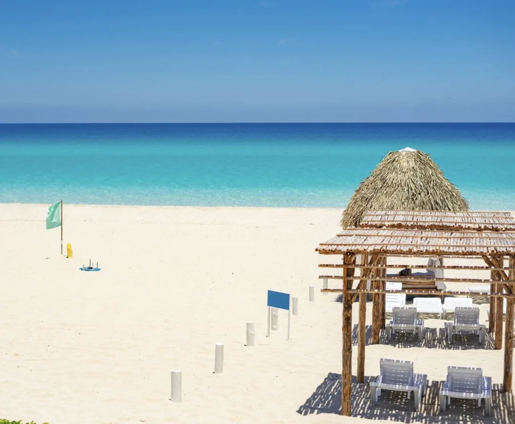 Beach Palapas and chairs on a white sand beach with aqua blue ocean at an all inclusive resort in Varadero