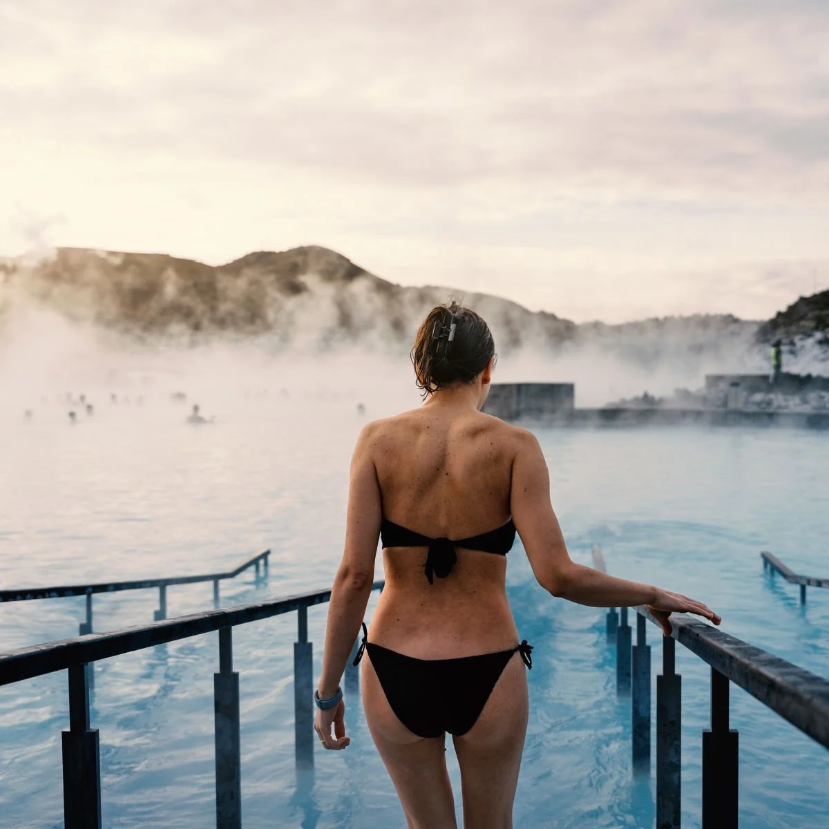 Woman in swimwear entering Iceland's famous Blue Lagoon