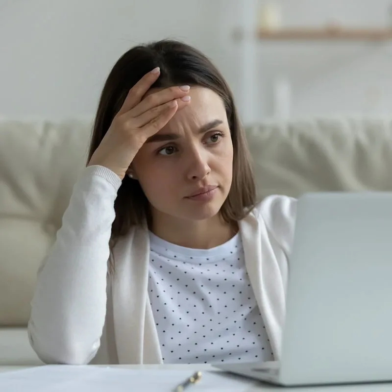 Young Woman Looking Worried As She Works From Her Computer.jpg